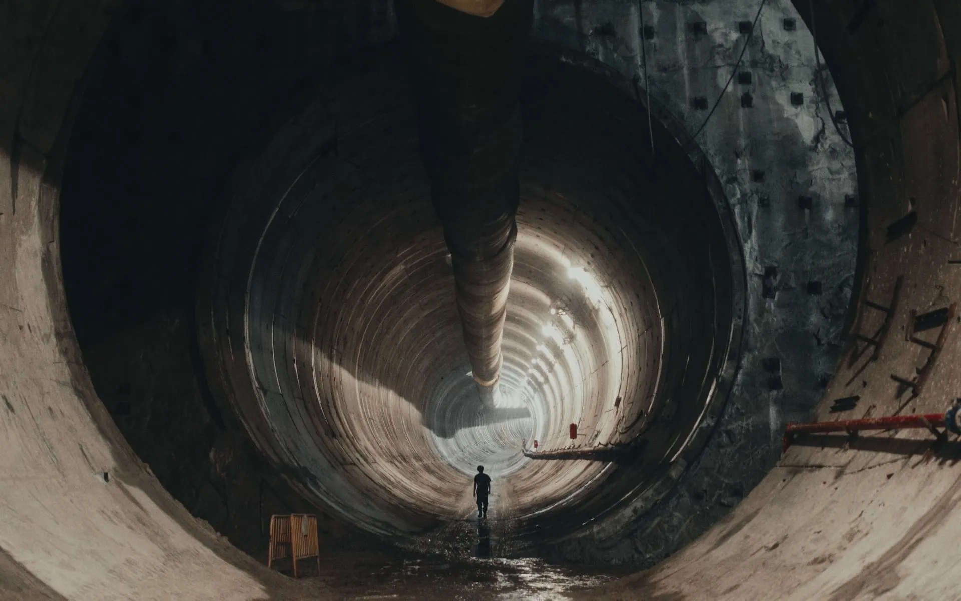 View down a deep industrial shaft with circular metal structures, from a film production by L'Imagerie Films.