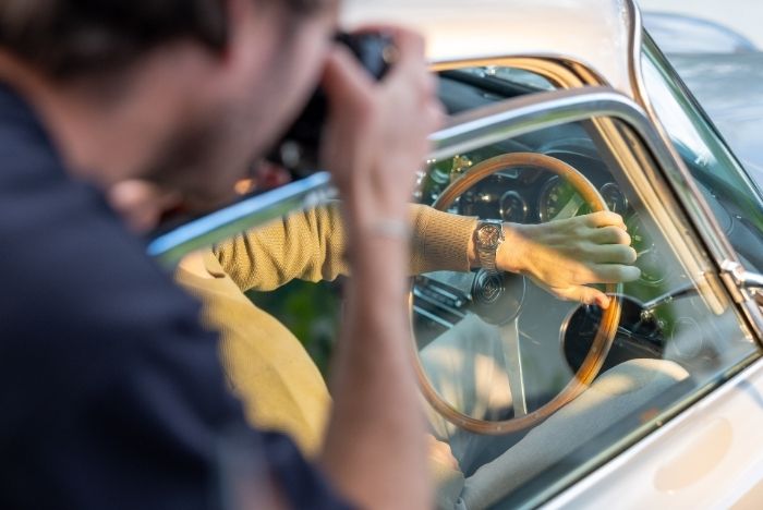 Photographer captures a wristwatch on a driver’s hand during luxury brand film production by L'Imagerie Films.
