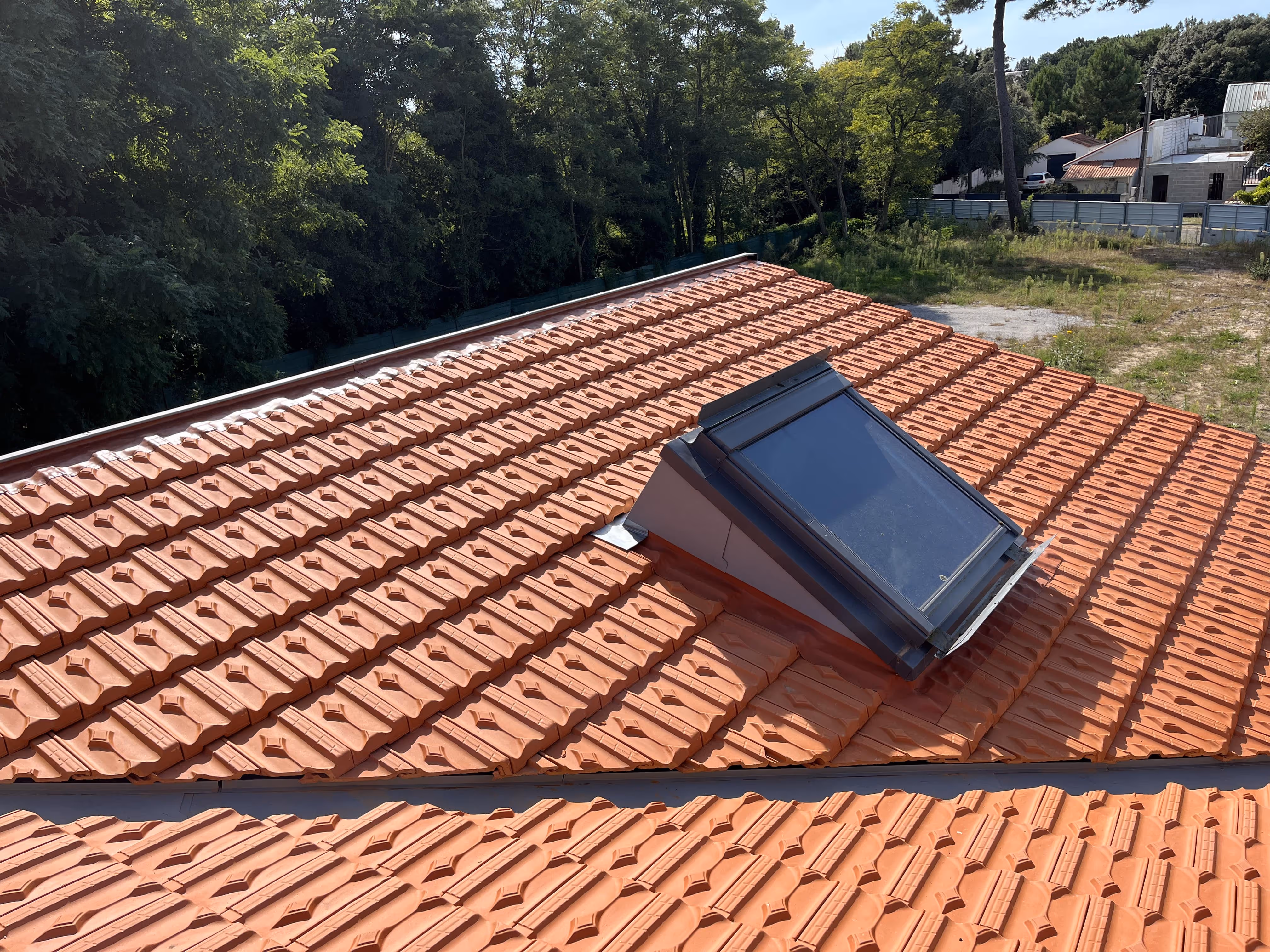 Toiture en tuiles avec pose d’une fenêtre de toit.