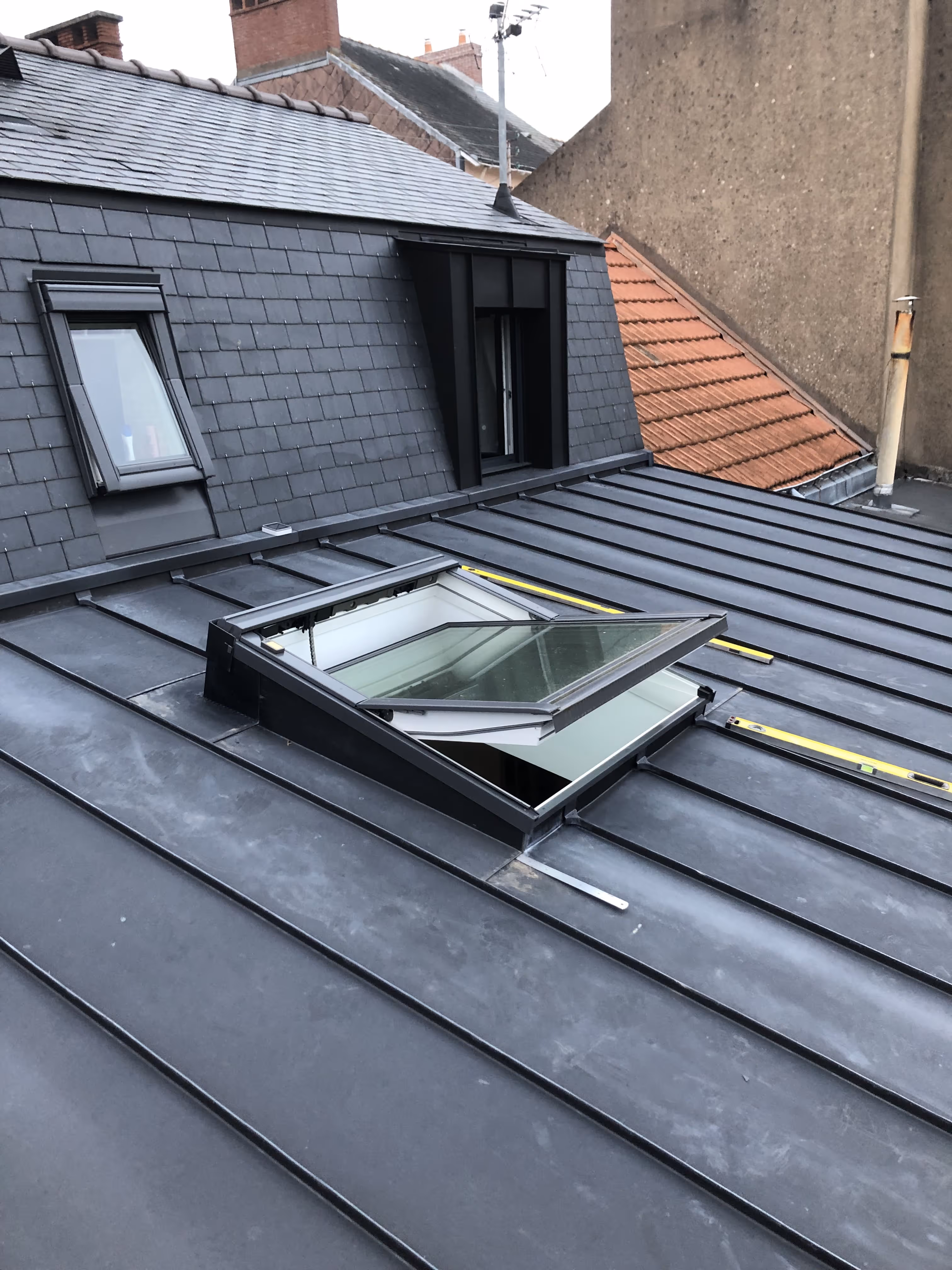 Finition de toiture en zinc avec habillage des rives et fenêtre de toit, Nantes.