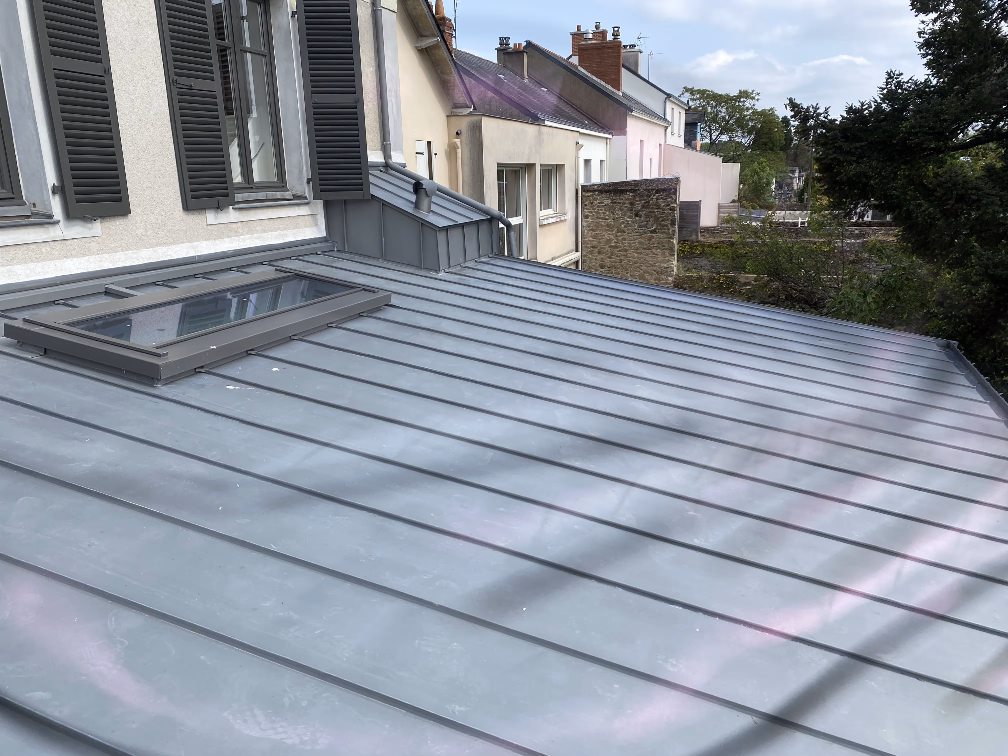 Finition de toiture en zinc avec habillage des rives et fenêtre de toit, Nantes.