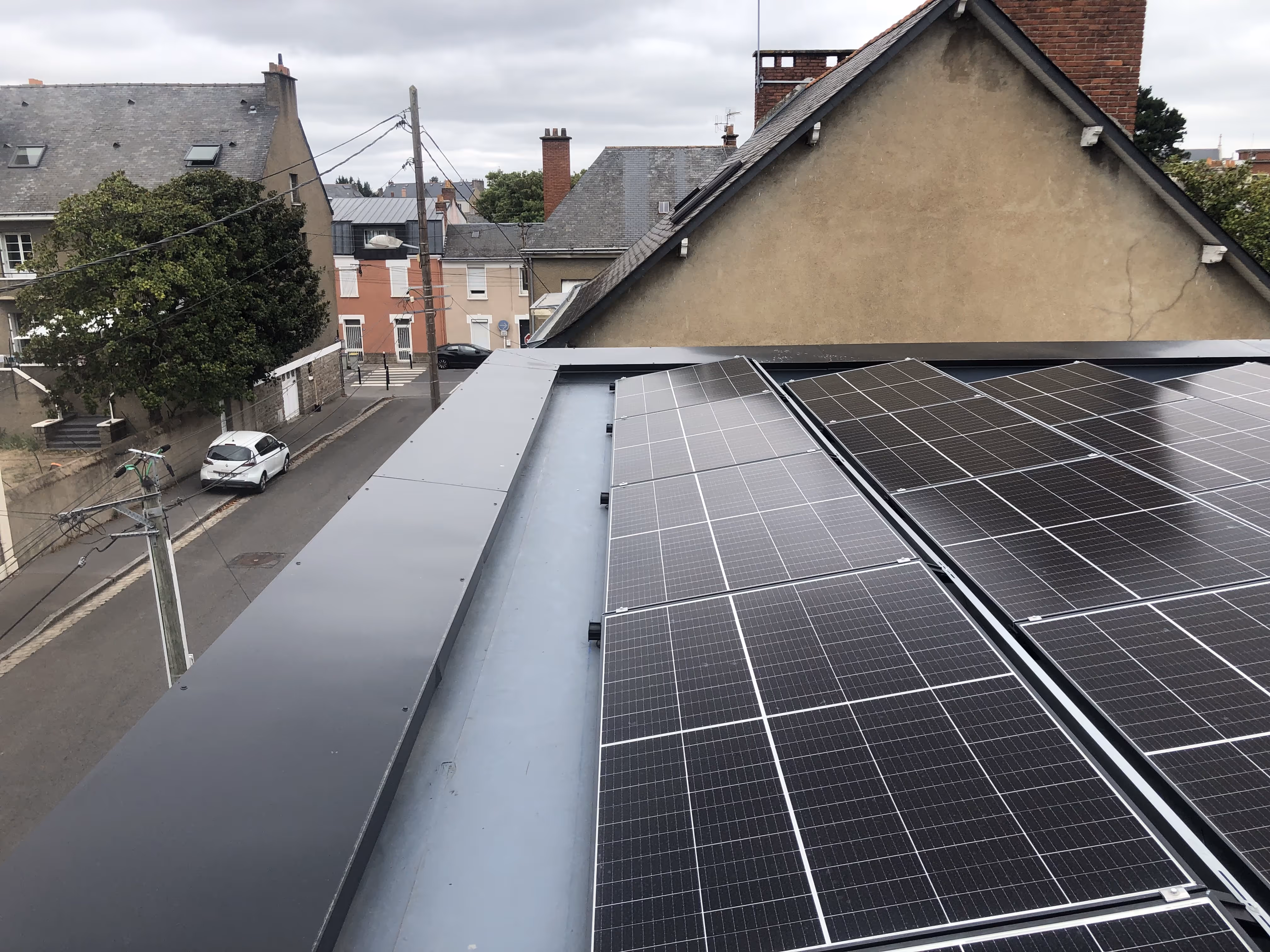 Installation de panneaux solaires photovoltaïques sur une toiture plate étanchée avec membrane PVC, incluant un système d’évacuation des eaux pluviales, Nantes.