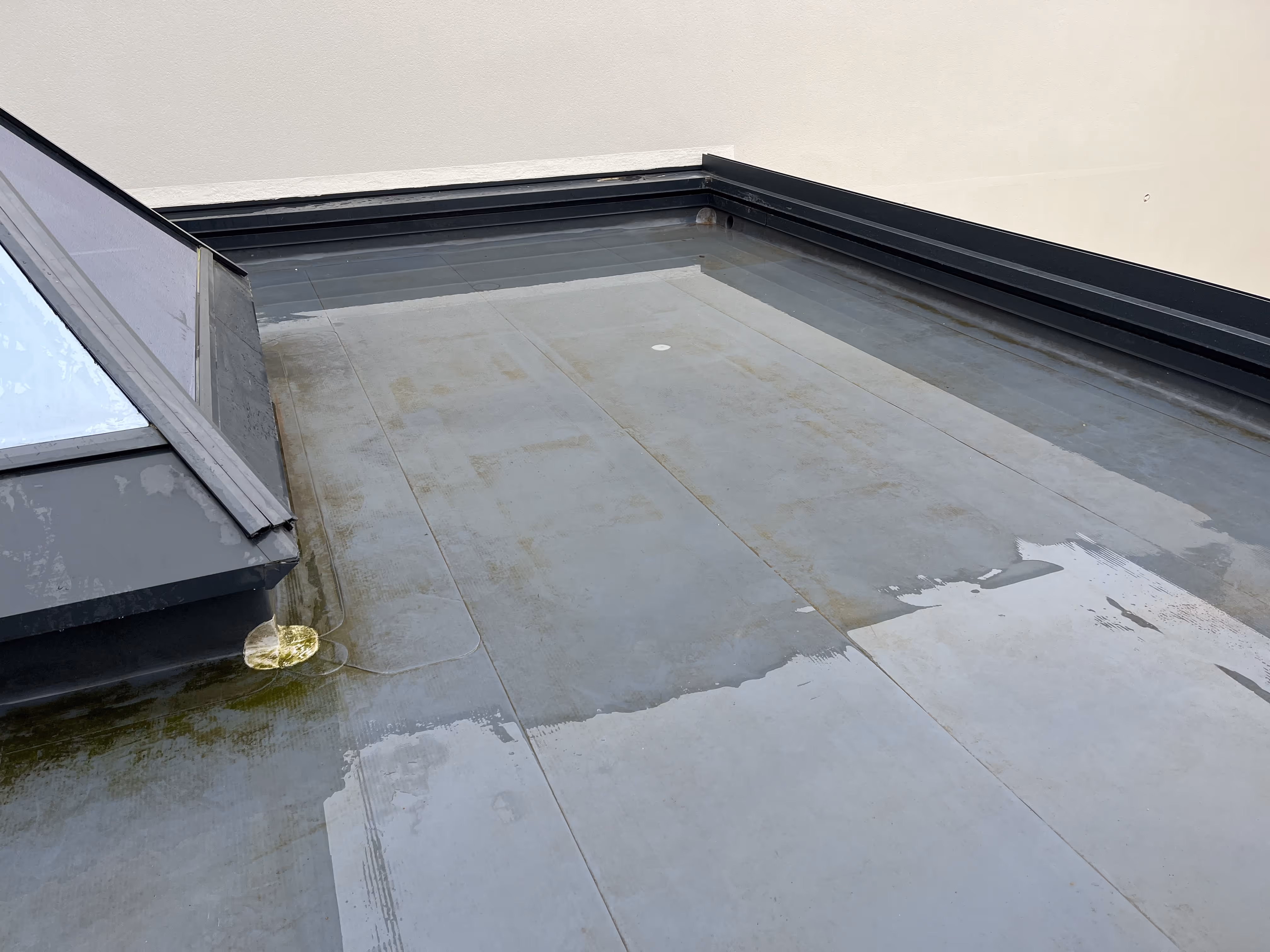 Toiture plate en cours d’étanchéité avec membrane PVC, détails de finition et raccords autour d’une fenêtre de toit, Nantes.