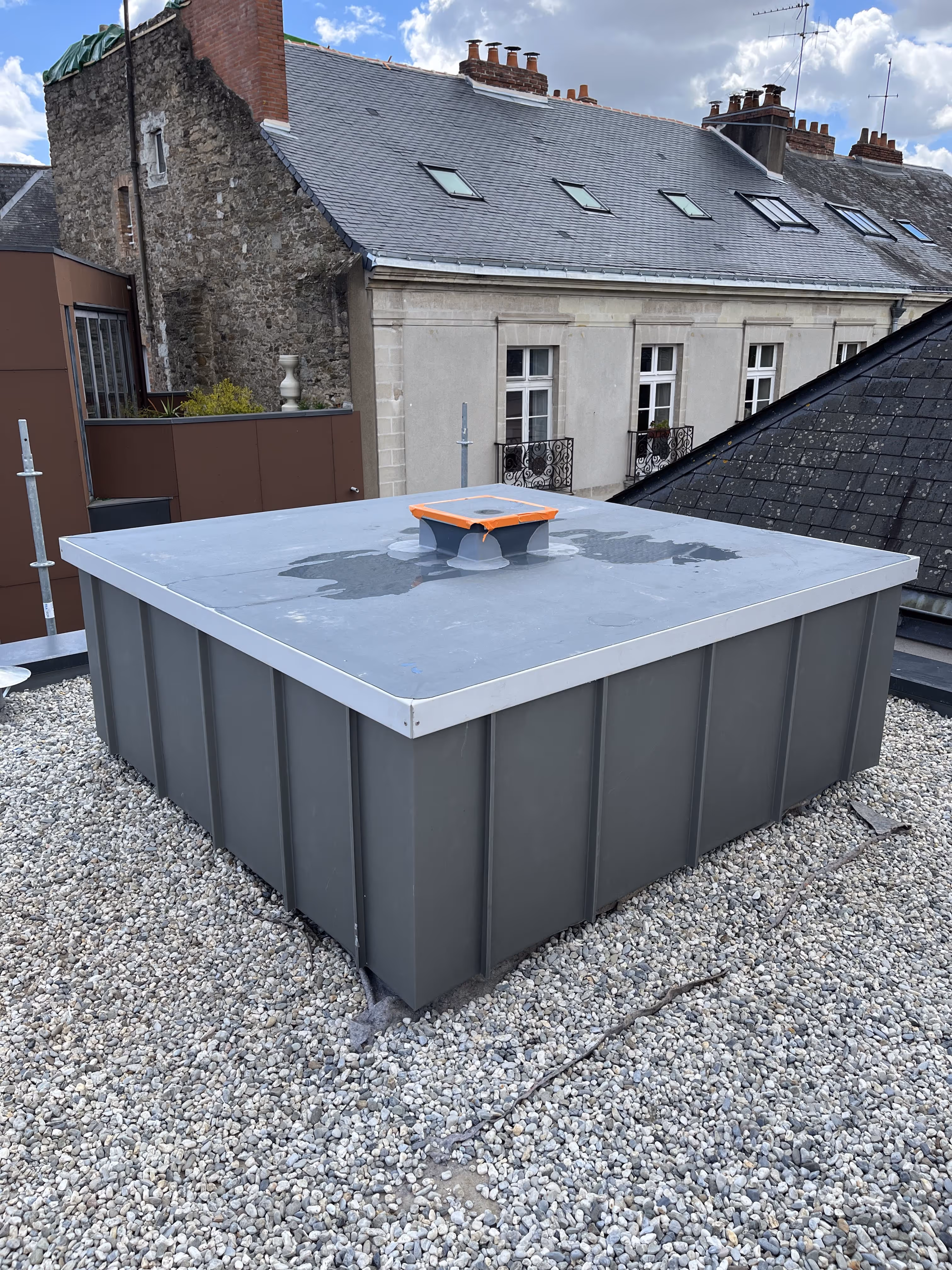 Installation d’une protection étanche sur une toiture-terrasse avec bac de rétention et ventilation centrale, posée sur un lit de graviers, Nantes.