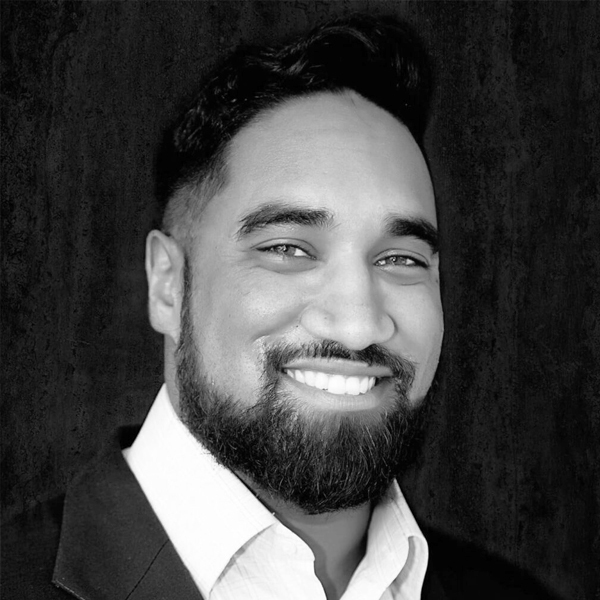 Joey Bose, Cytonics CEO, smiling in a suit jacket and button-down shirt