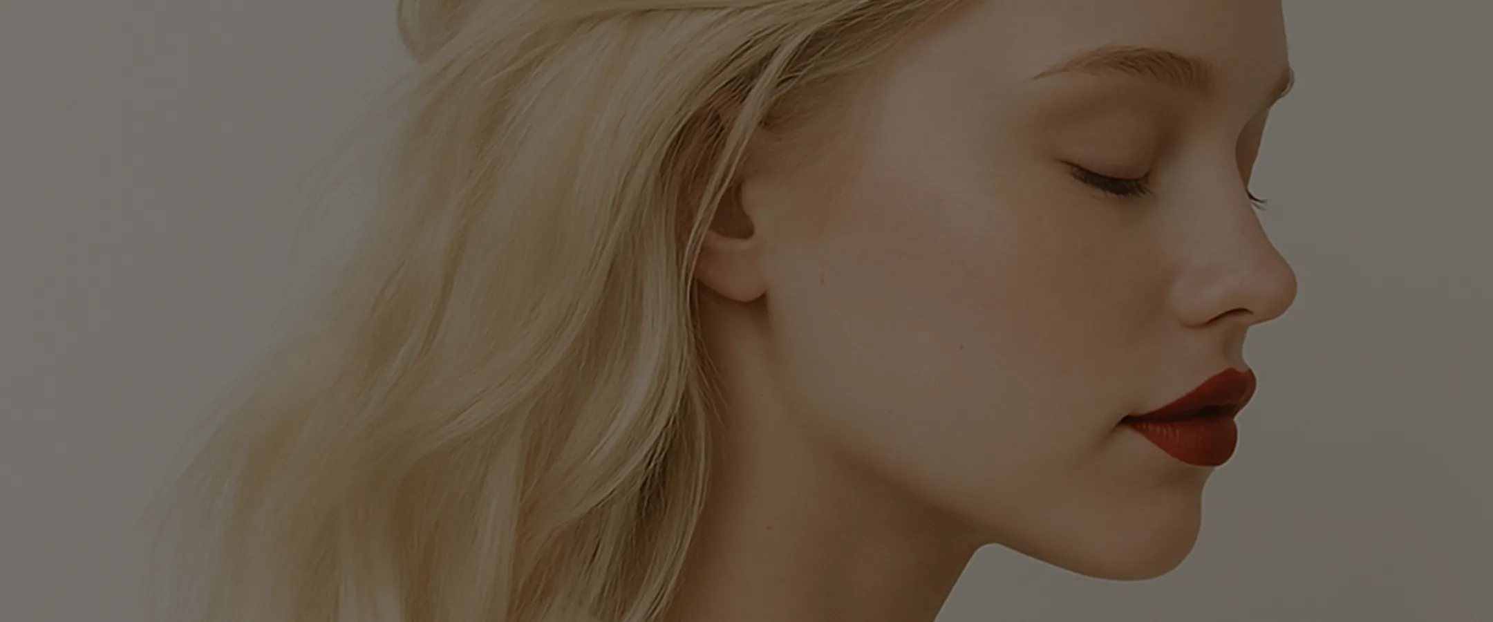 A woman with long blonde hair and red lipstick.