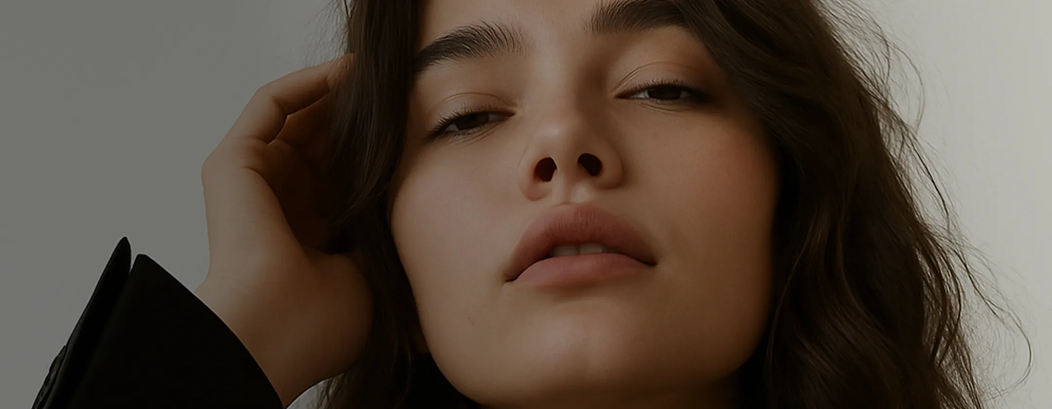 A close up of a woman with her hand on her head.