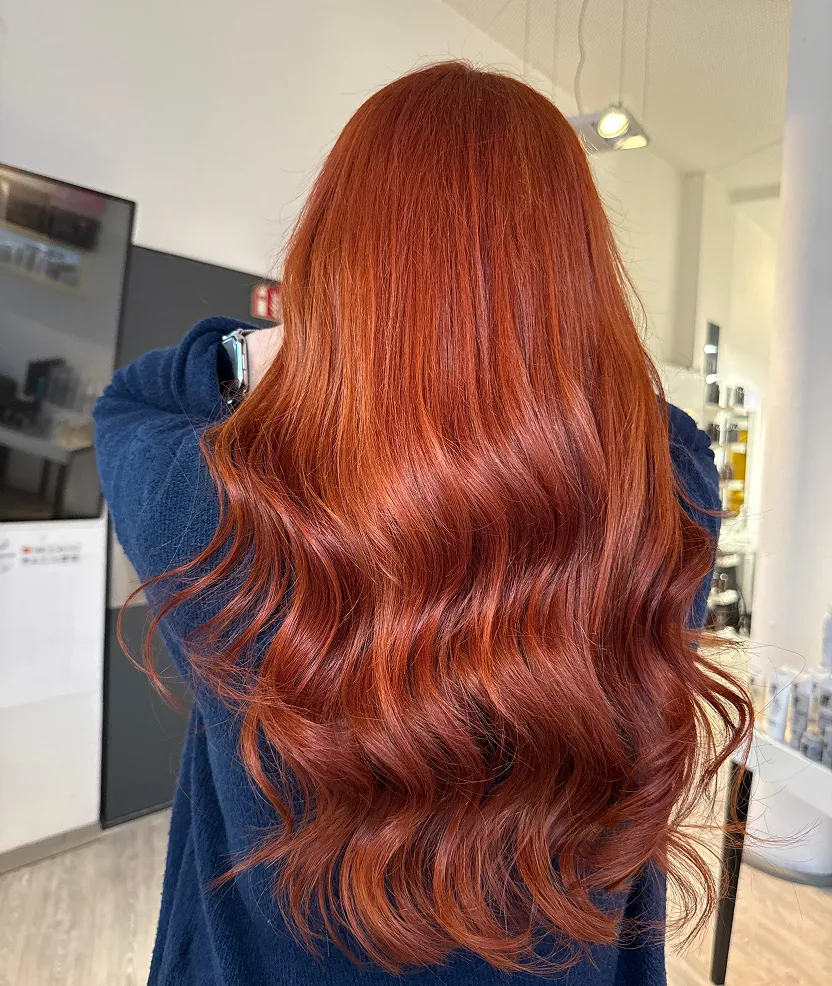 A woman with long red hair in a salon.
