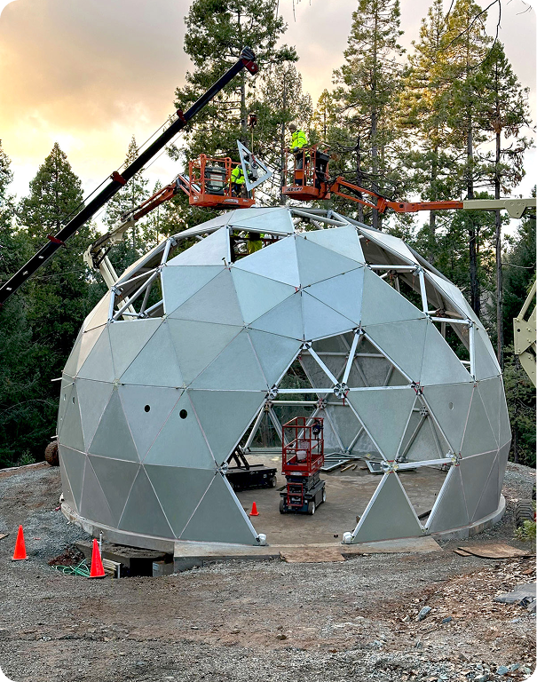A white dome shaped houses in a forest.