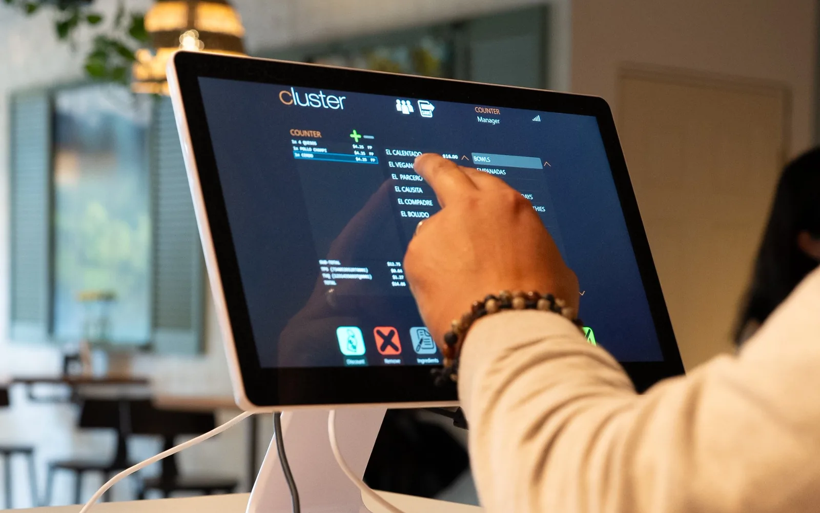 A server taking an order on a Standard POS (V1) terminal at a restaurant counter