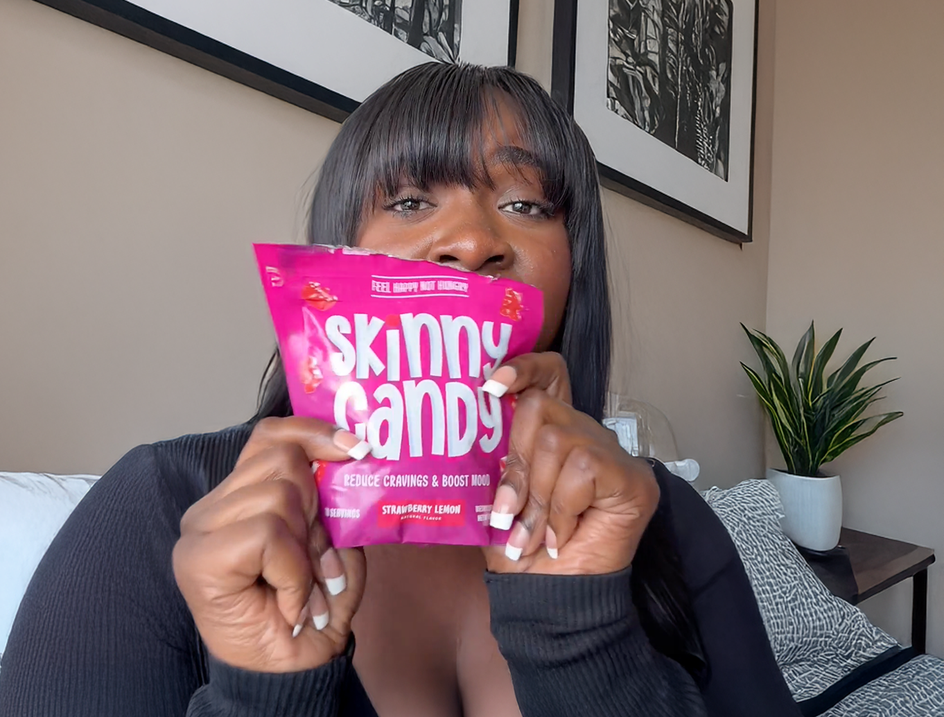 A woman holding up a pink candy bar.
