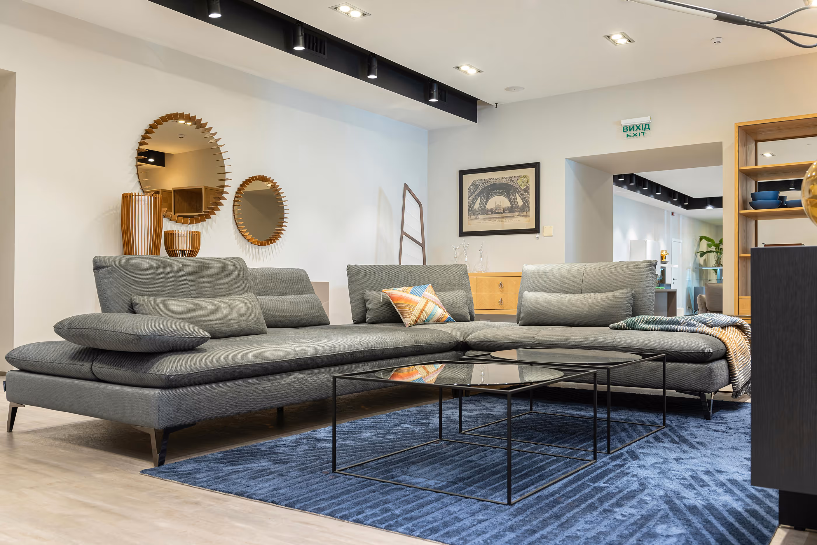 Gray sectional sofa with black coffee table and blue rug