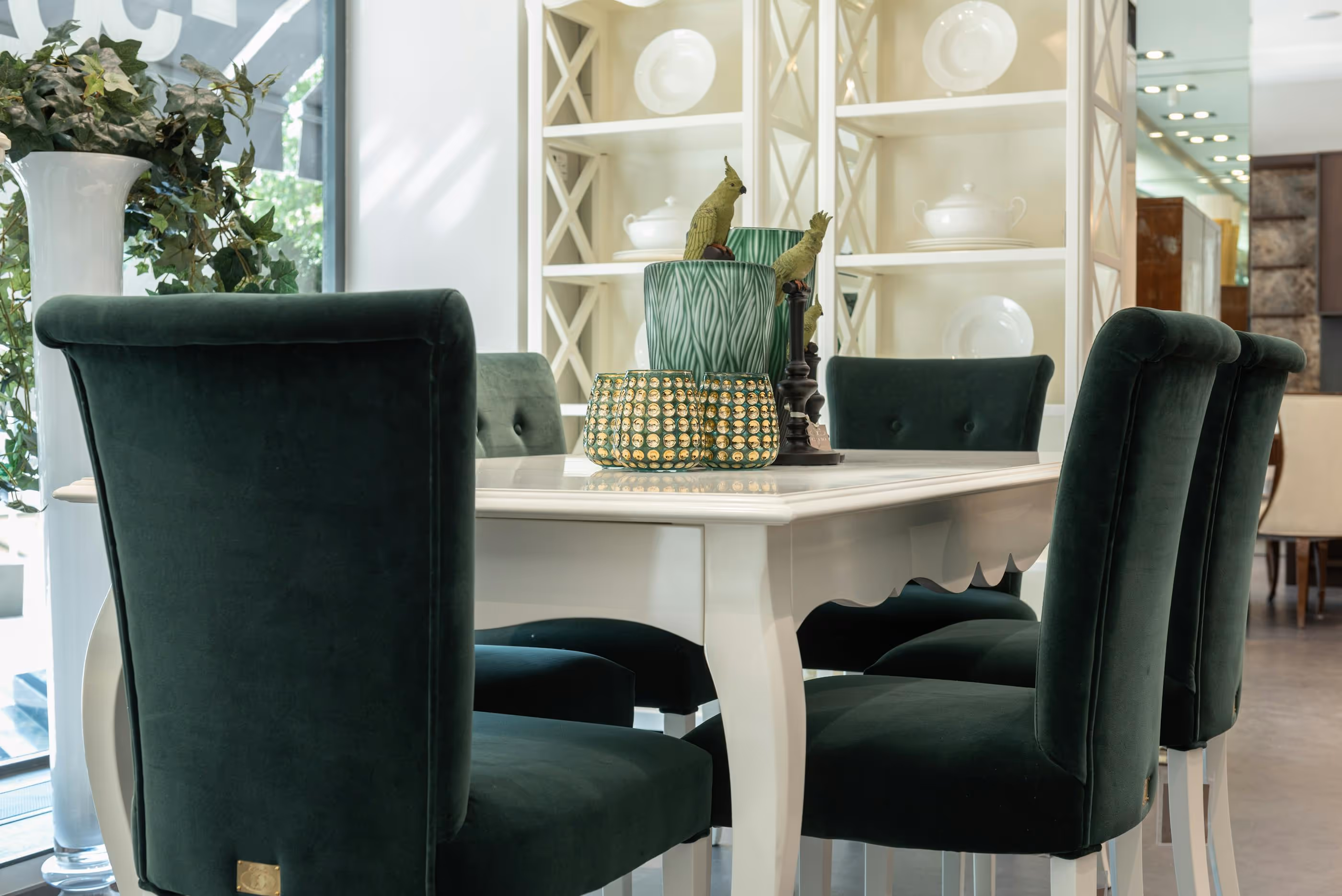 White dining table with green velvet chairs