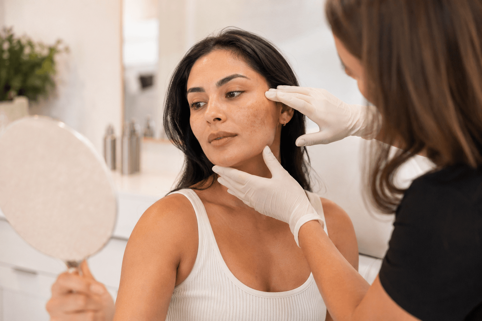 Woman receiving a professional skin evaluation for hyperpigmentation treatment in Southlake, Texas before Halo, Moxi, or TRL laser treatment.