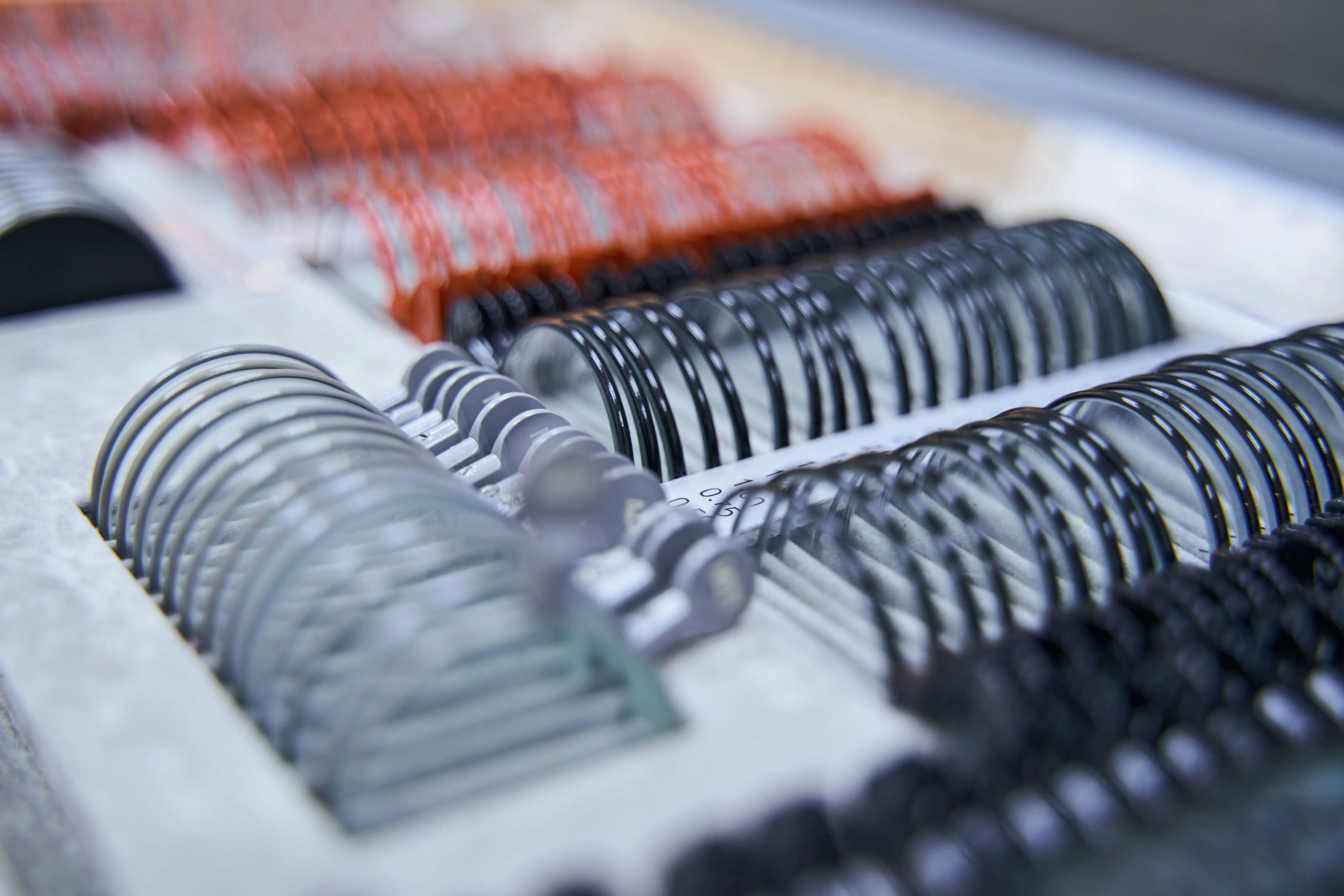 Spiral bound book bindings in black, gray, and red close-up