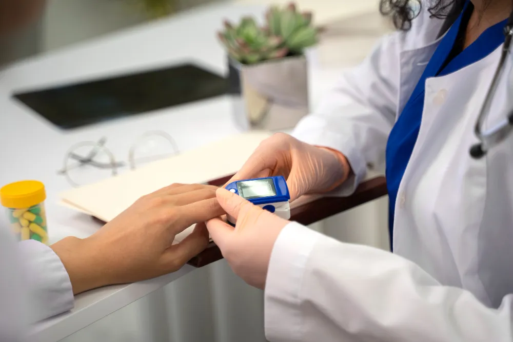 Healthcare professional checking patient's pulse with digital pulse oximeter