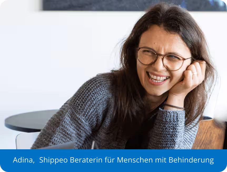 Lächelnde Frau mit Brille und langen dunklen Haaren in einem grauen Pullover mit der Bildunterschrift Adina, Shippeo Disability Advisor.