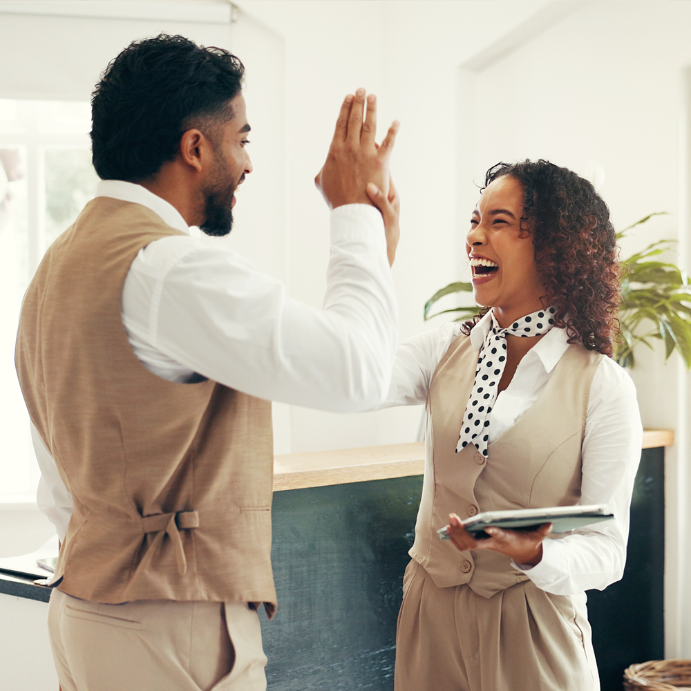 Hotel staff giving high fives to each other after successfully launching Bonomi that saves them valuable time.