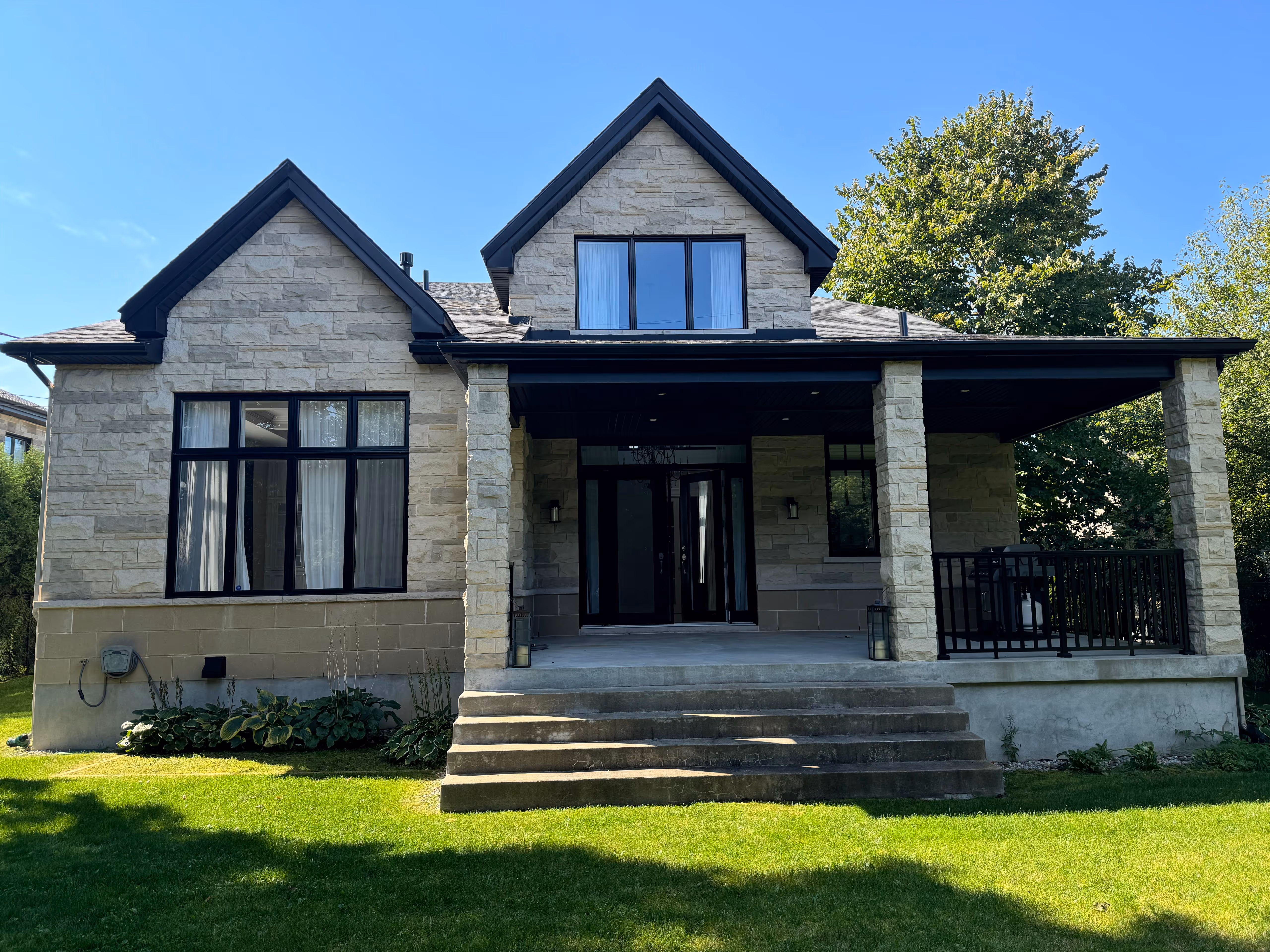 Projet résidentiel clé en main réalisé par SCI Globale Inc. — maison unifamiliale moderne avec façade en pierre et grand porche.