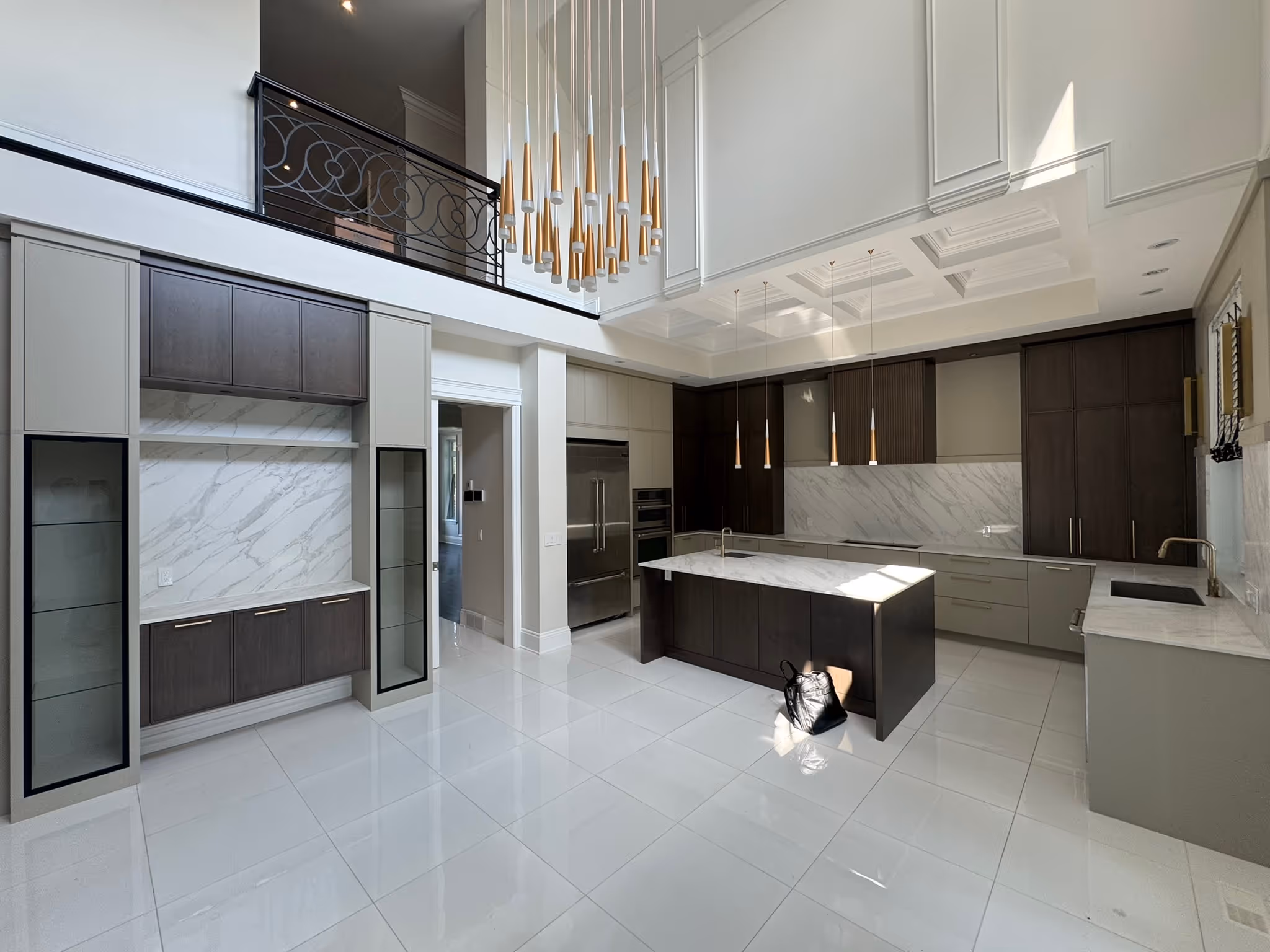 Interior view after renovation, showing a modern kitchen with a central island, light flooring, and high ceilings.