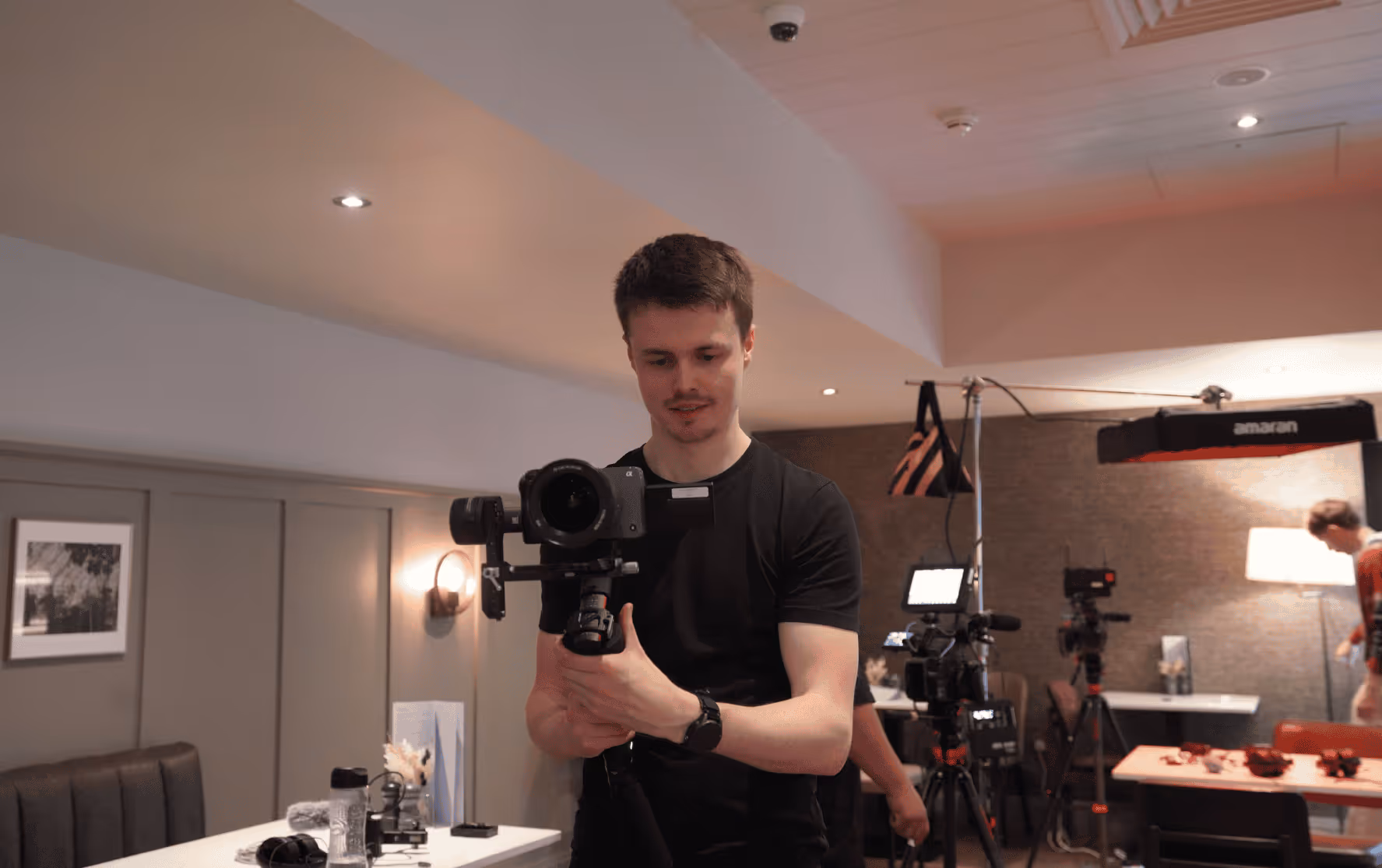 Sam Head, marketing manager at REAS Group, preparing camera equipment for video production
