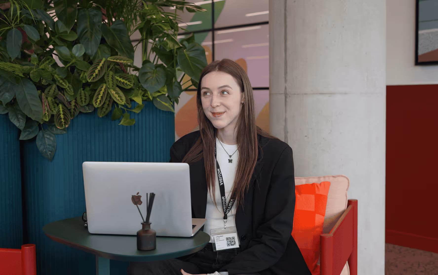 Diana Romanenko, web developer at REAS Group, working on a laptop in modern office