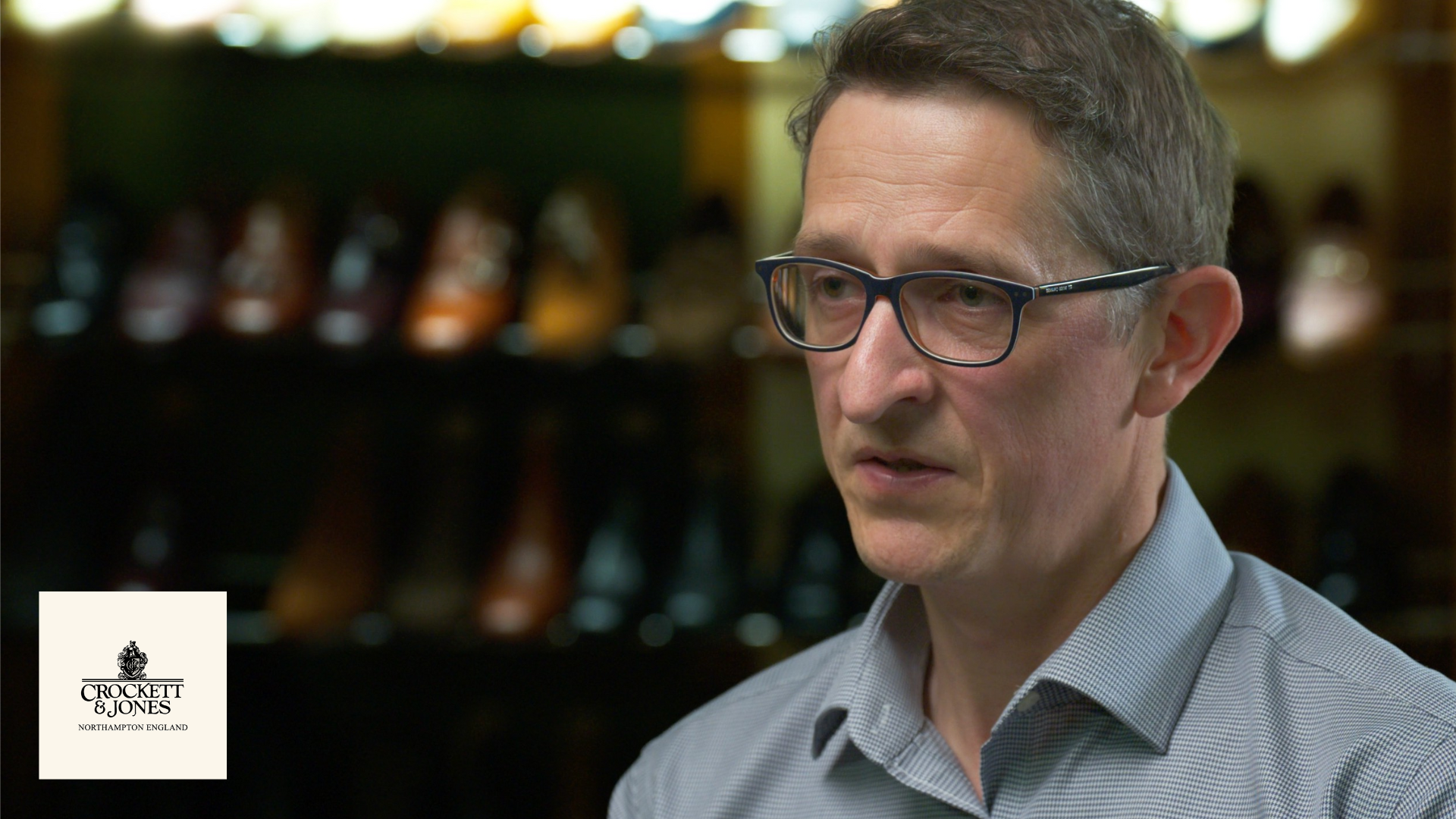 A Crockett & Jones representative interviewed in-store for a Managed247 video testimonial, with handmade shoes displayed behind him