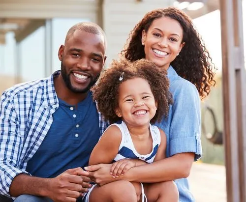 A man and a woman with a child, smiling for the camera.