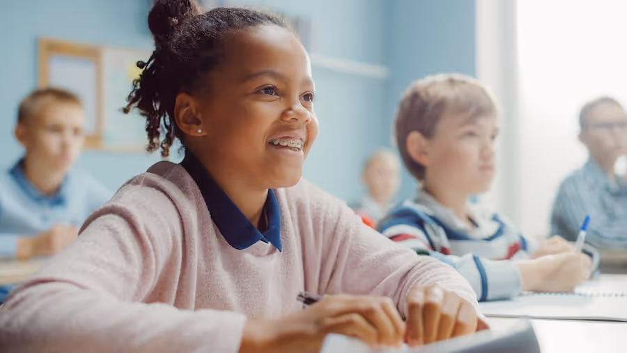 A group of children sitting at desks in a classroom.