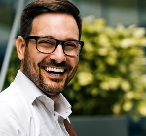 man smiling after undergoing cosmetic dental procedure