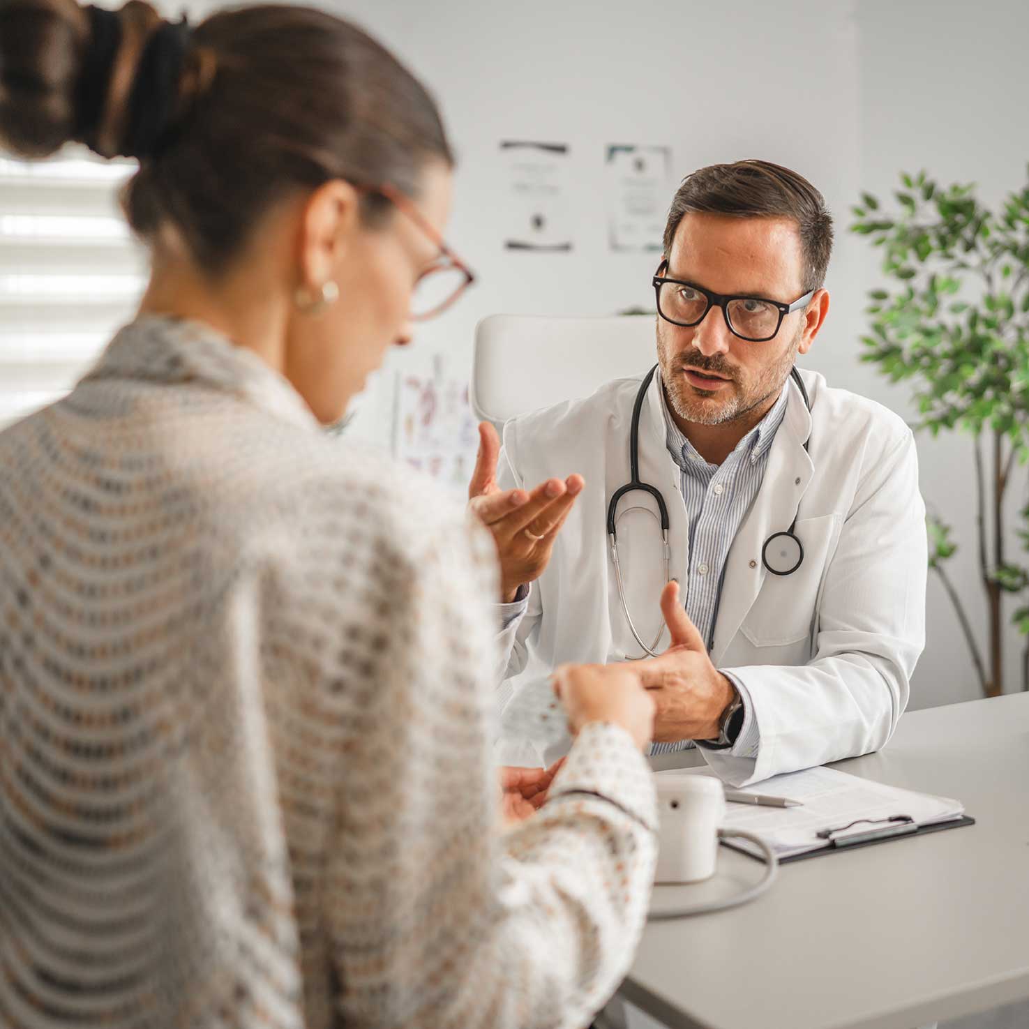 Doctor examining patient's shoulder and arm mobility during clinical assessment