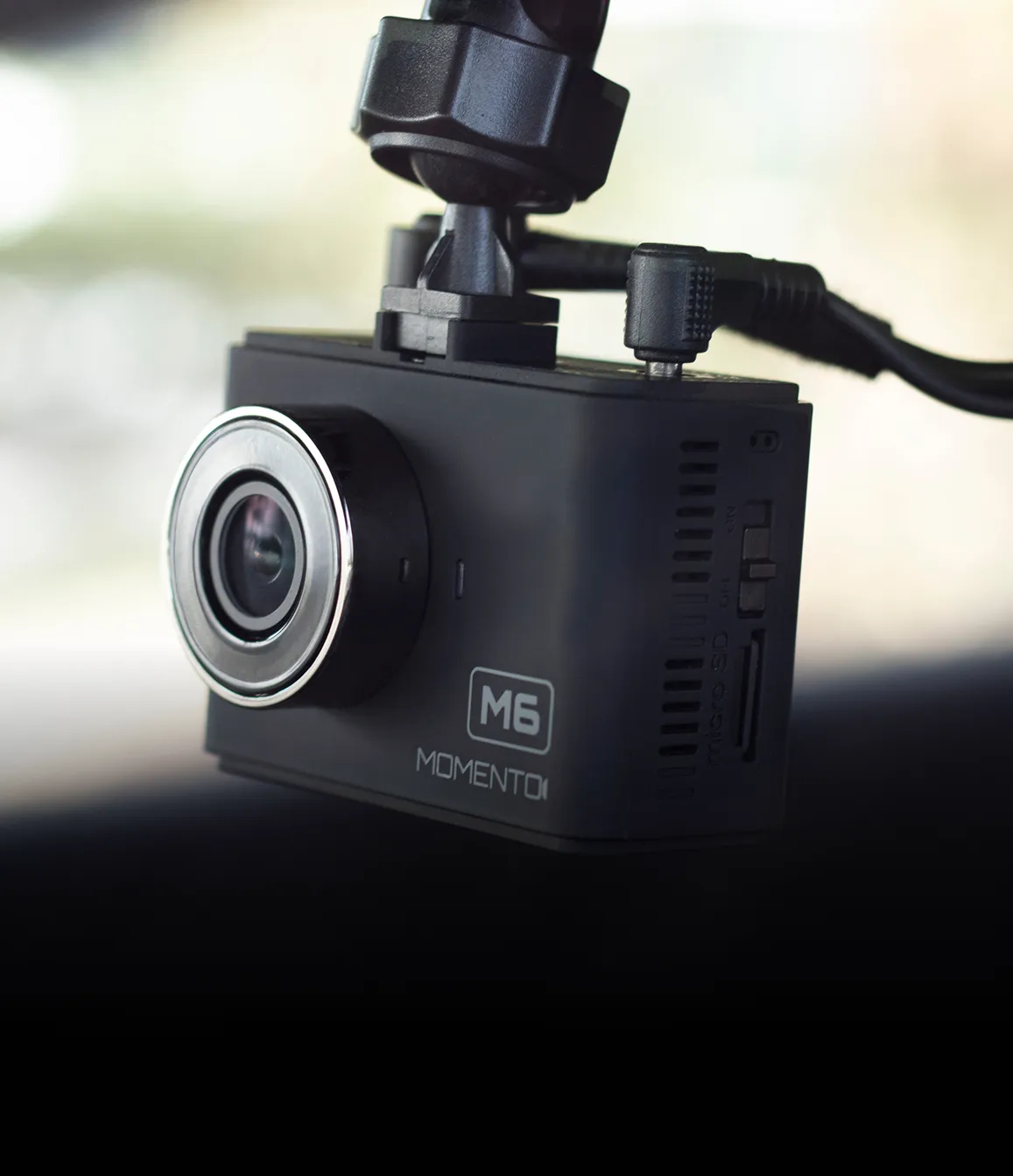 Black rectangular dashboard camera labeled Momento M7 with a round lens in the center.