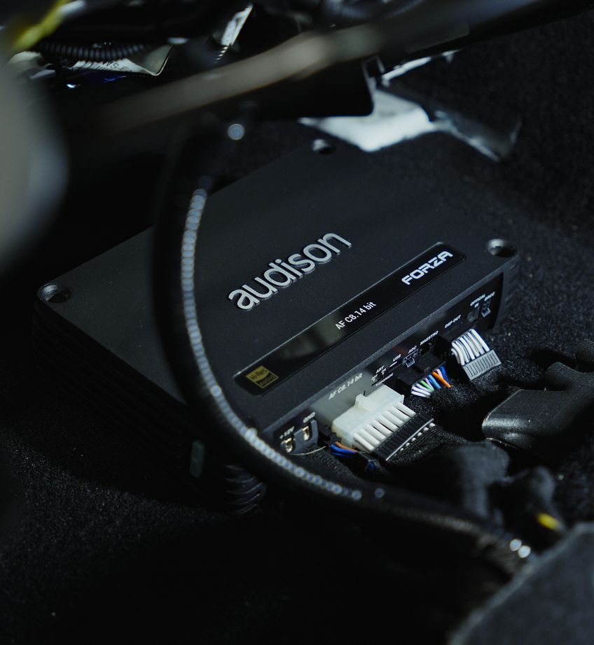 Audison DSP installed with connected wires under a car seat.