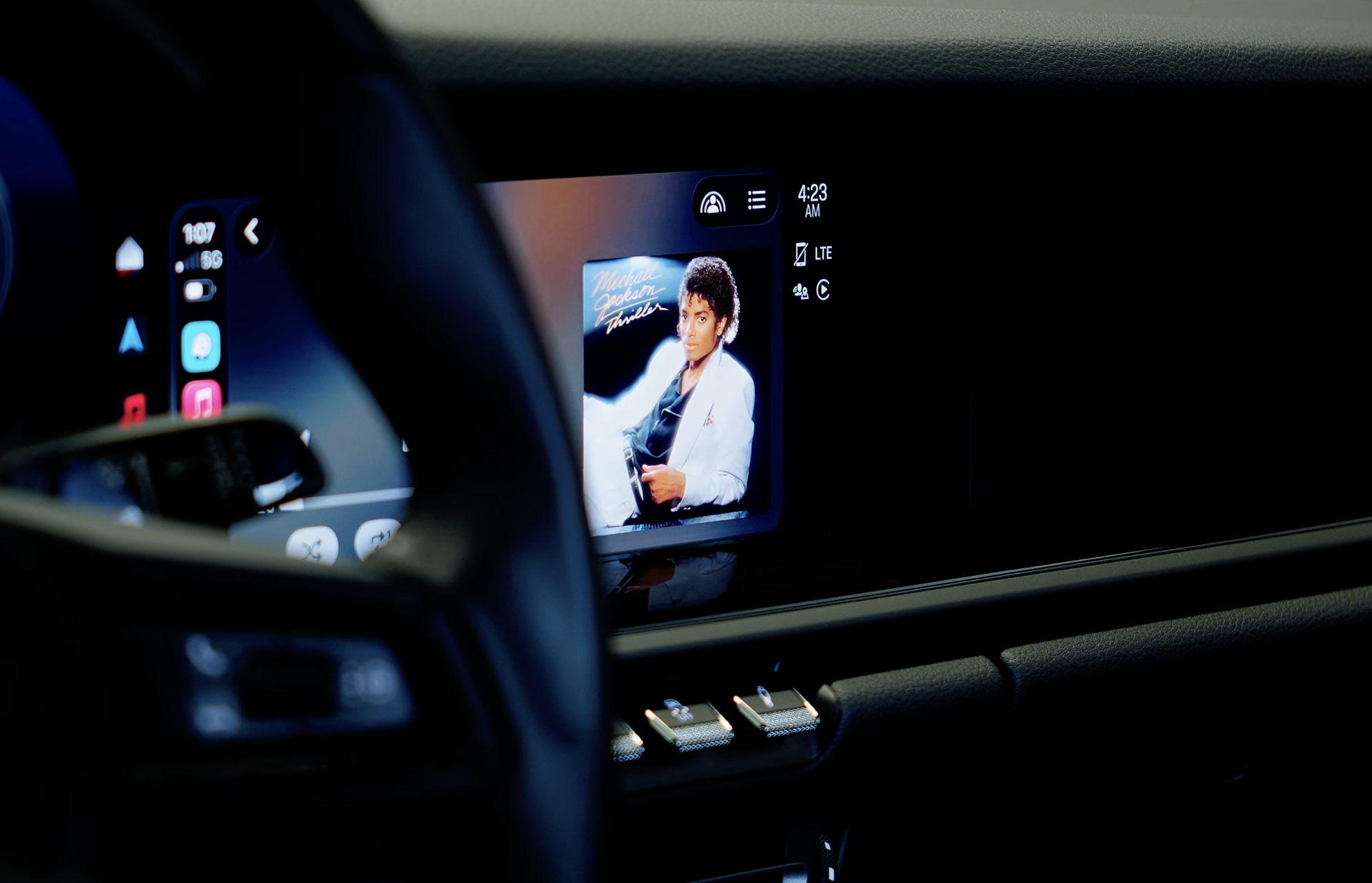 Car dashboard screen showing Michael Jackson Thriller album cover and music app interface at 4:23 AM.