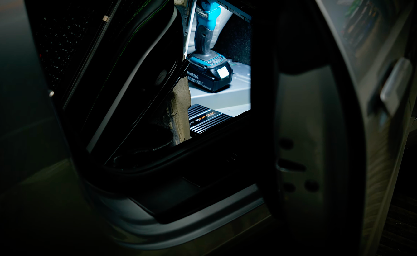 Open car door showing interior with a cordless drill and a Match DSP.