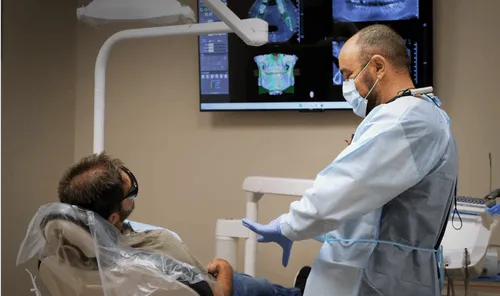 A man sitting in a chair in a dentist's office.