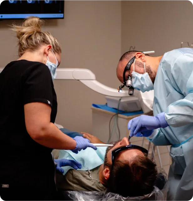 A man in a dentist chair getting his teeth checked.