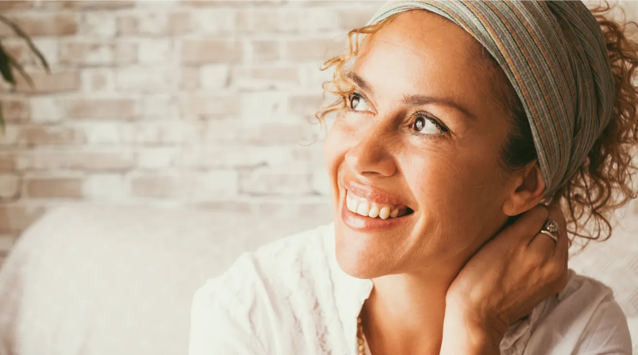 A woman with a headband smiling at the camera.