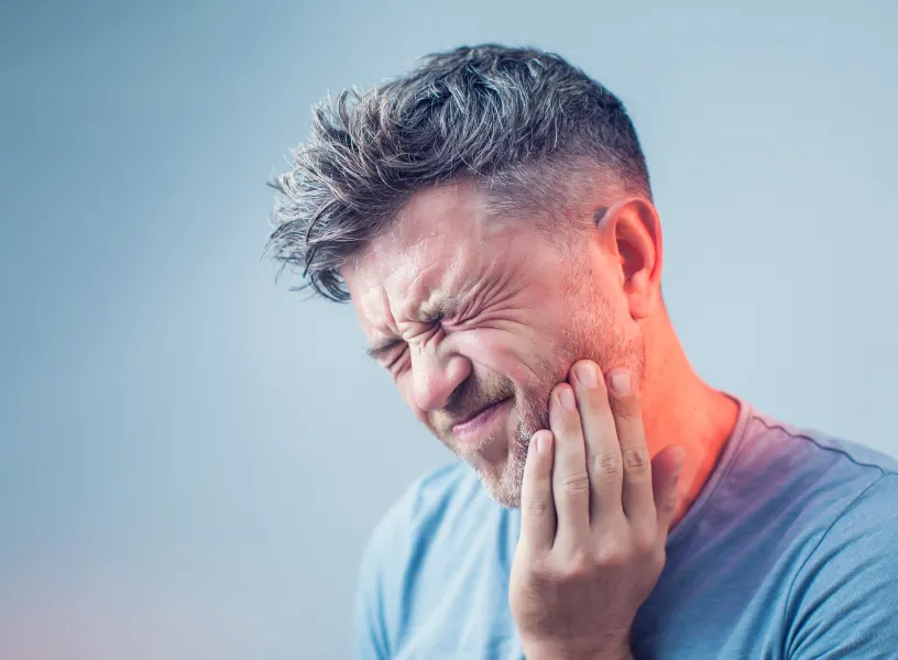 A man with a sore holding his hand to his ear.
