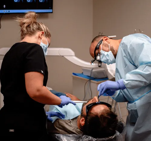 A man laying on a bed in a dentists office.