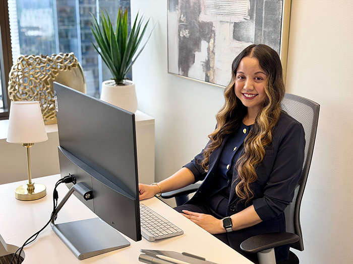 Veura CEO Catherine Kay Magsino working behind a monitor and smiling.