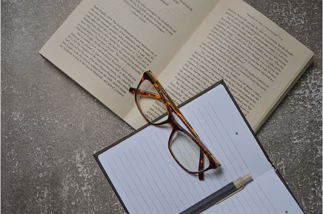 Ein Buch mit einer Brille drüber.