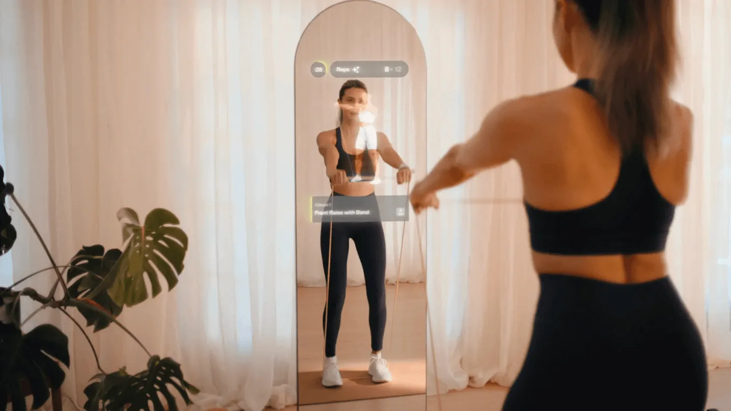 Woman doing a resistance band exercise in front of a smart fitness mirror