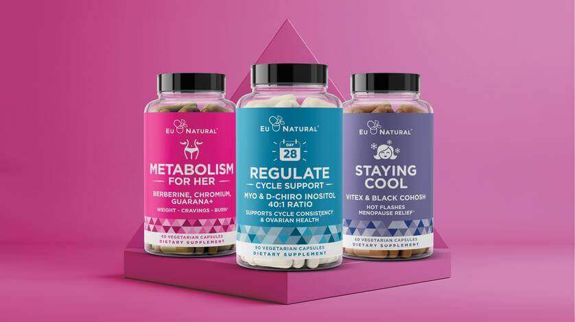 Three women's dietary supplement bottles on a pink pedestal against a pink background