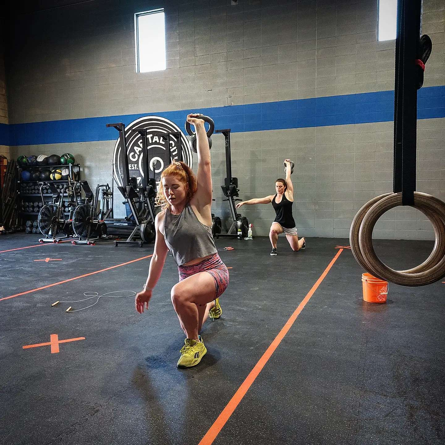 Capital City Athletics members performing single arm kettlebell overhead lunges