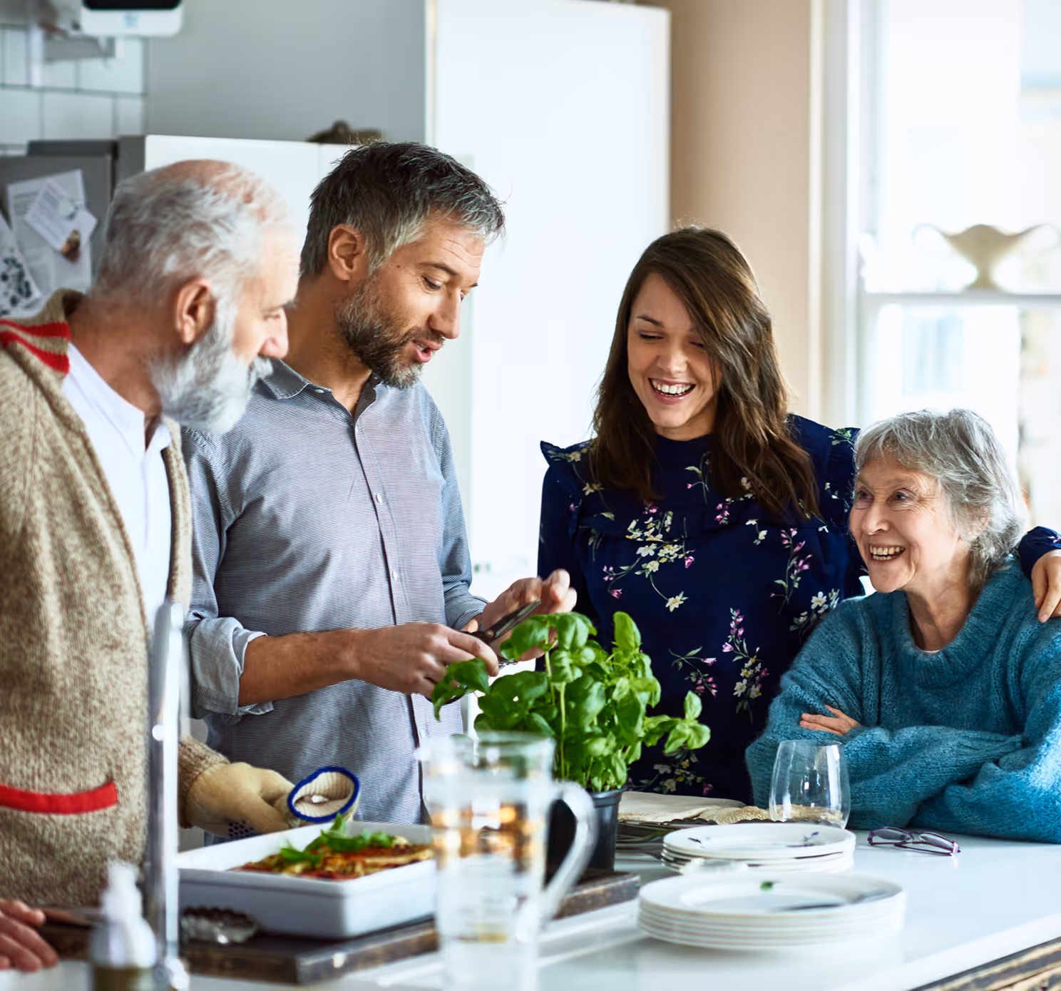 a family standing around a kitchen island smiling and talking