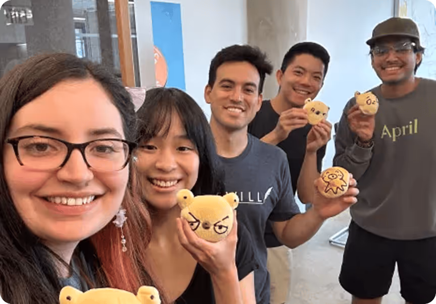 A group of people holding up stuffed toys.