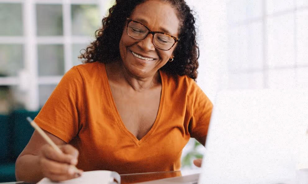 a woman smiling and writing a document