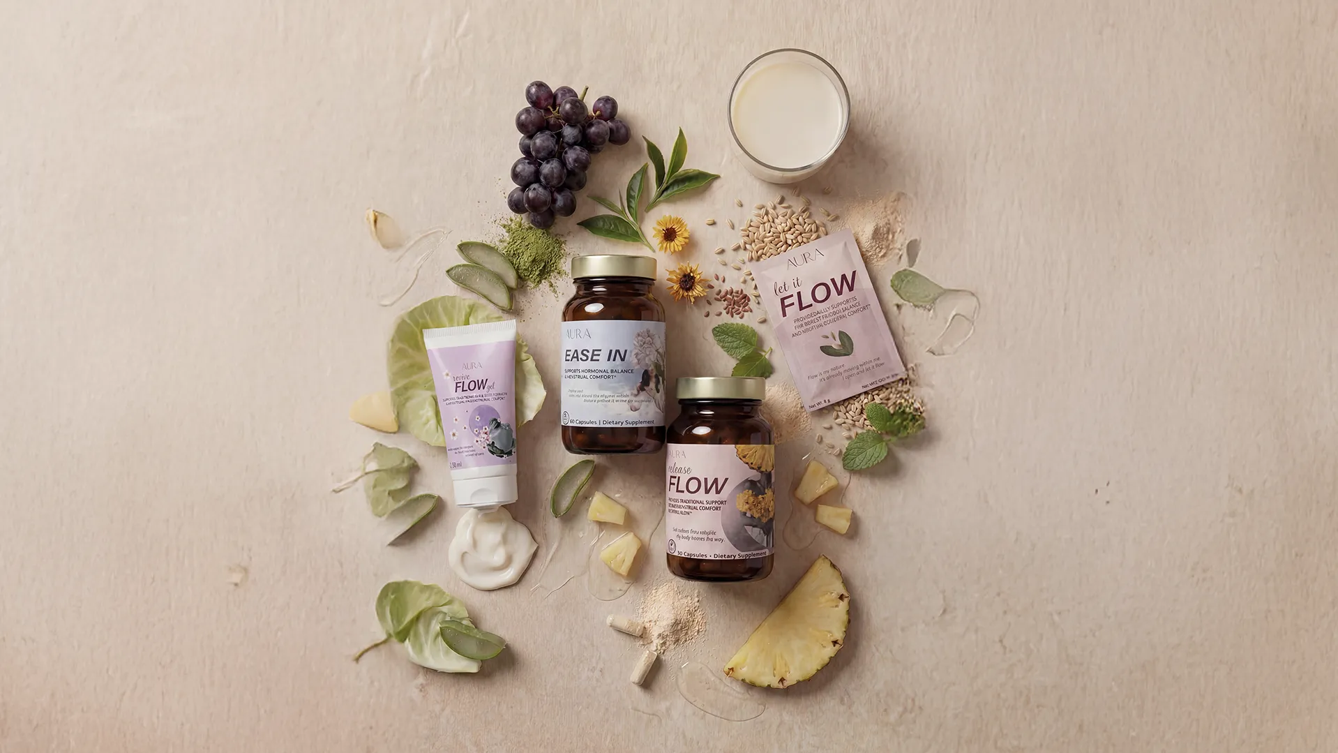 Dietary supplement bottles and tube surrounded by natural ingredients like grapes, aloe, pineapple, and leaves.