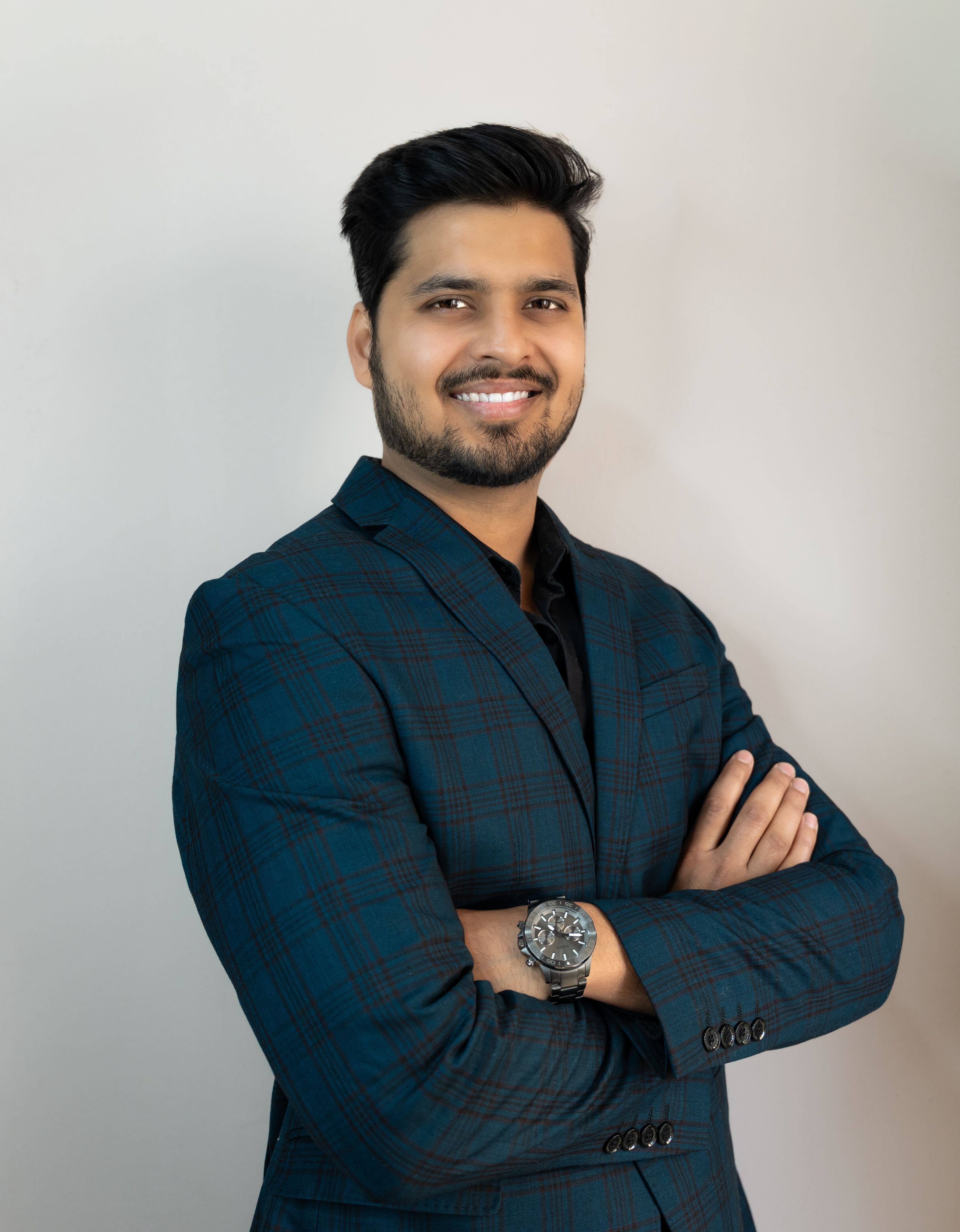 Aerial view of a large two-story suburban house on a corner lot with manicured lawn, surrounding trees, and a fenced backyard with a swimming pool.